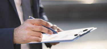 gros-plan-homme-affaires-verification-presse-papiers