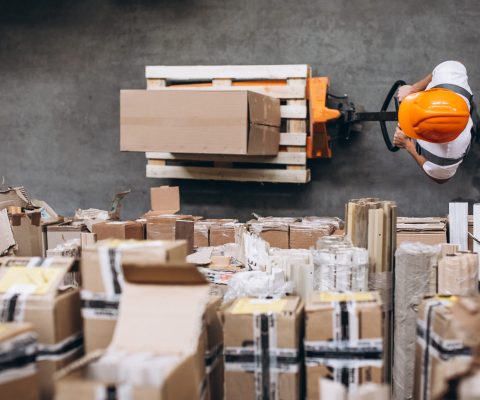 Young man working at a warehouse with boxes